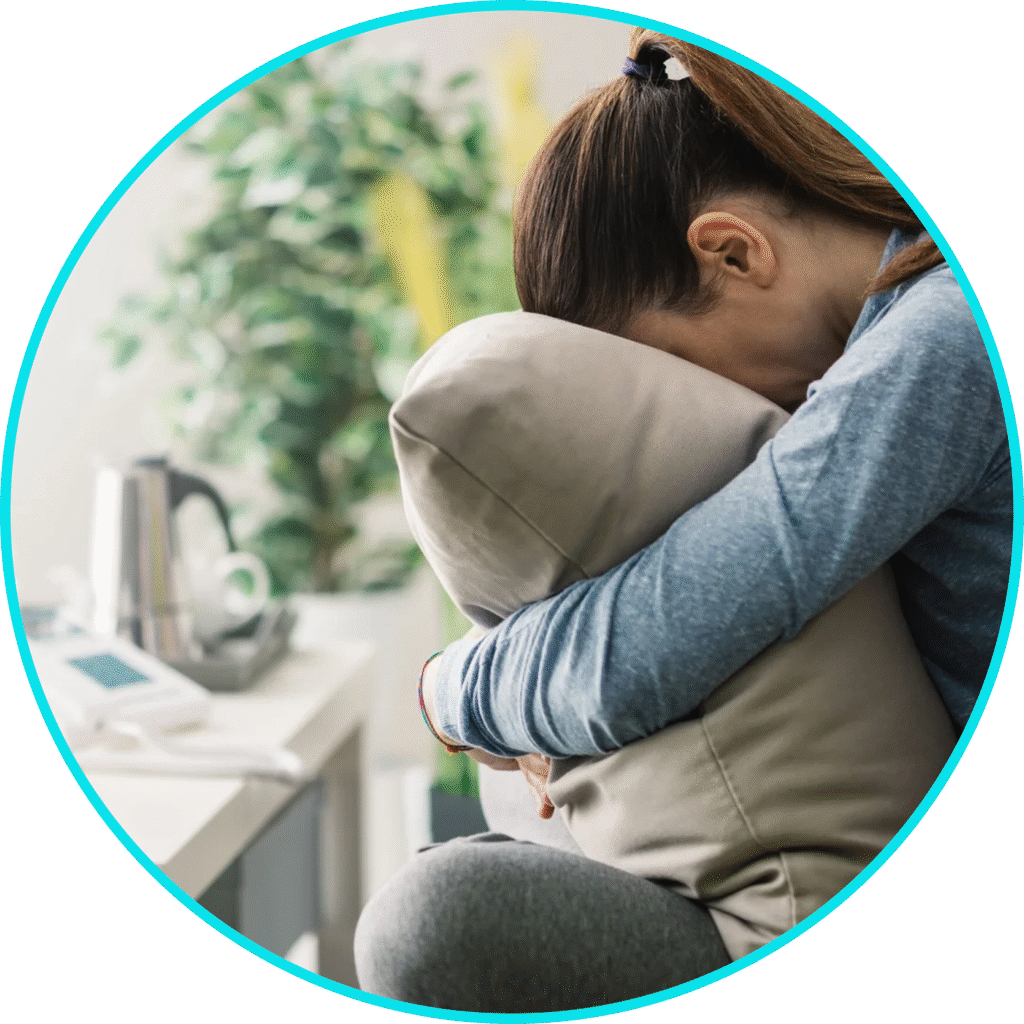 A woman holding her pillow sitting down